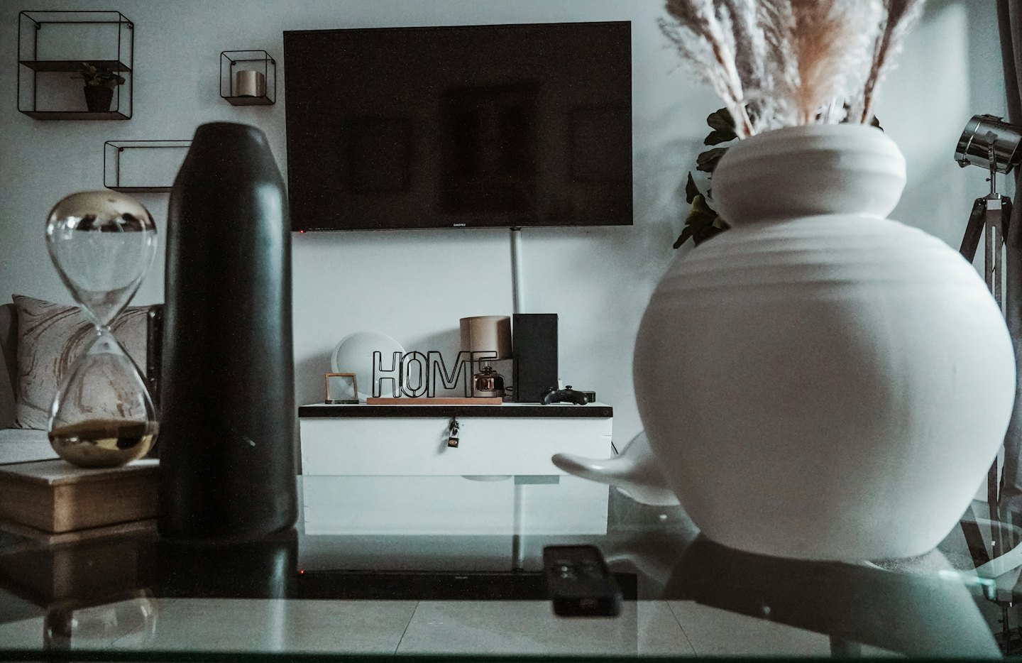 Sala de estar moderna con mueble de TV y mesa de centro de cristal.
