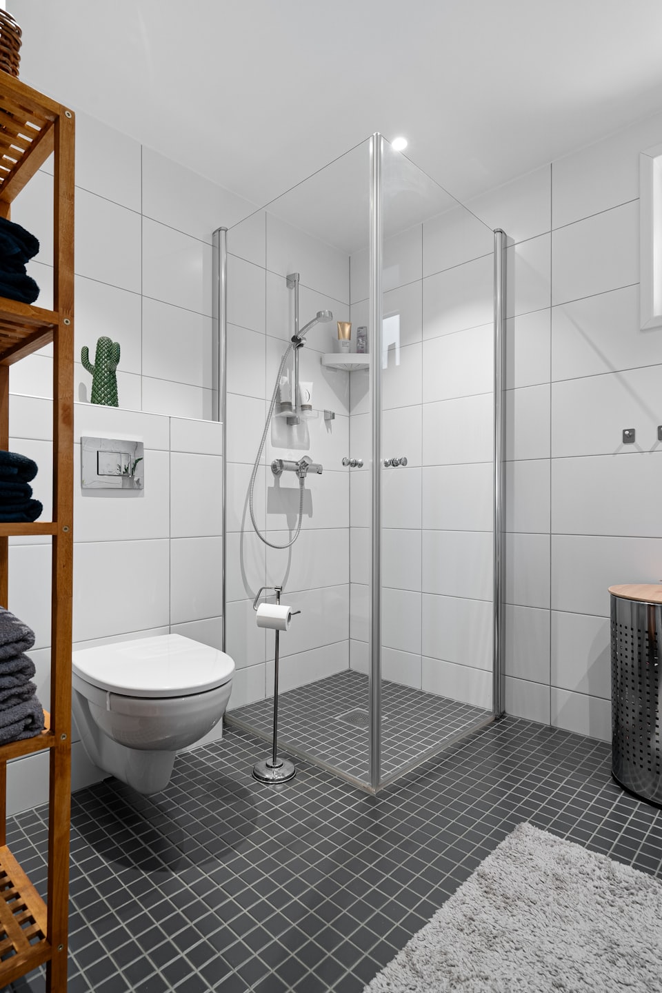 Baño moderno con ducha y toallas apiladas ordenadamente.