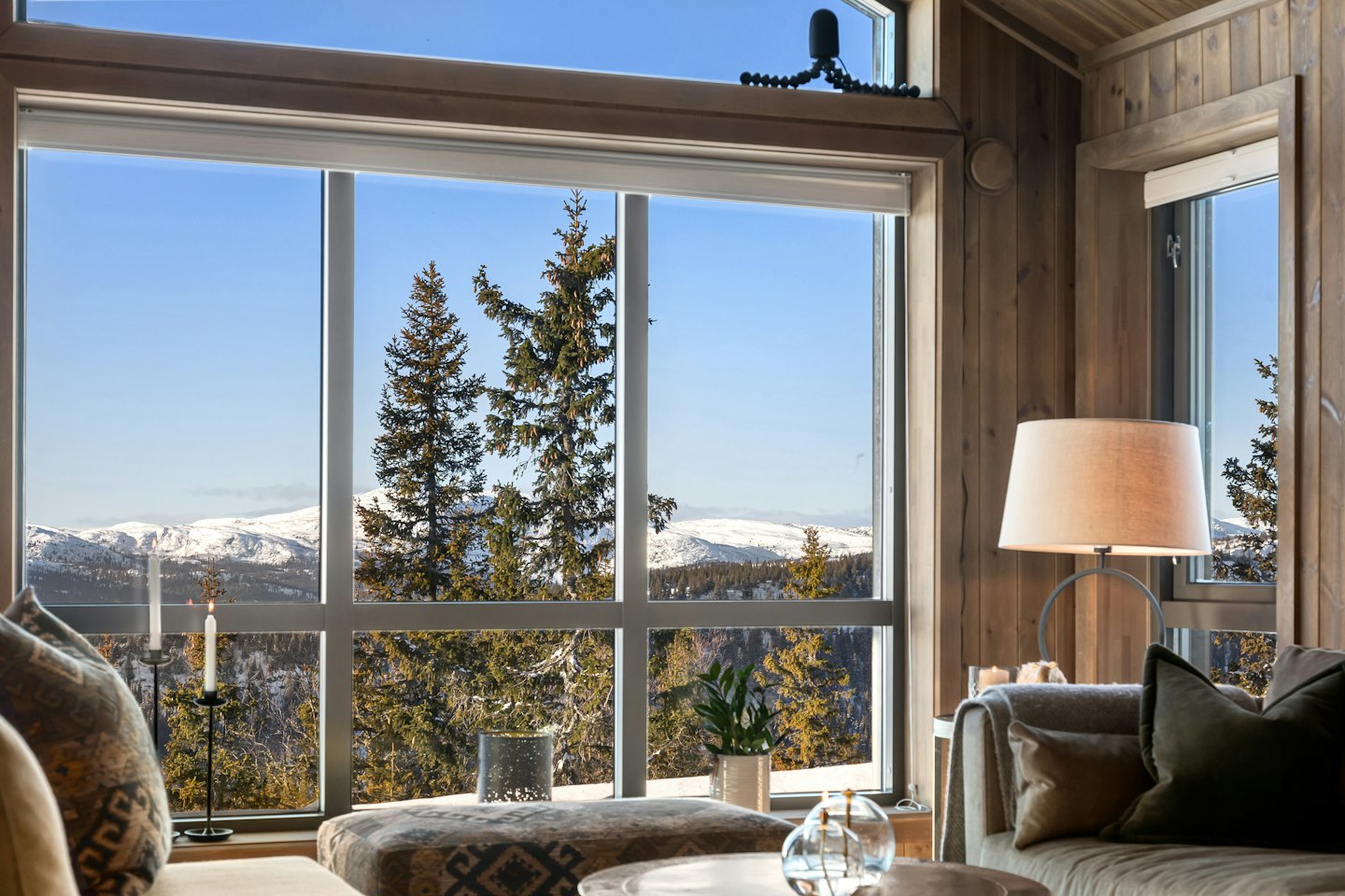 Sala de estar con vistas a la montaña a través de grandes ventanales.